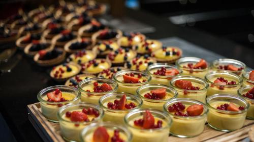 a bunch of desserts in small jars on a table at Thon Hotel Nordlys in Bodø