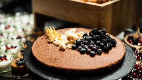 a chocolate cake with berries on top on a table at Thon Hotel Nordlys in Bodø