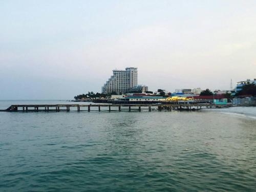 a pier in the middle of the water with a building at Klai Hat Inn in Hua Hin