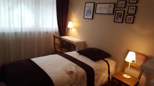 1 dormitorio con 1 cama, 1 mesa y 2 lámparas en Les Petites Chambres de la Bleue Maison, en Coeuve