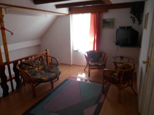 een woonkamer met 2 stoelen en een televisie bij Chalupa Anton in Horní Halže