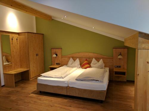 ein Schlafzimmer mit einem Bett mit einer grünen Wand in der Unterkunft Gasthaus Weingast in Bad Feilnbach