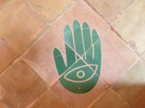 a green hand painted on a tile floor at Riad Mehdia in Marrakech