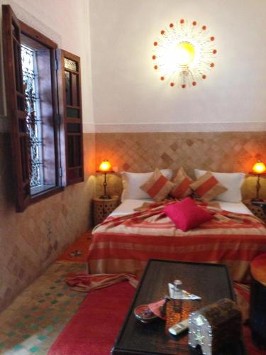 a hotel room with two beds and a table in a room at Riad Mehdia in Marrakech