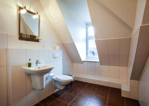 a bathroom with a toilet and a sink at Aparthotel Markt Fuffzehn in Stralsund