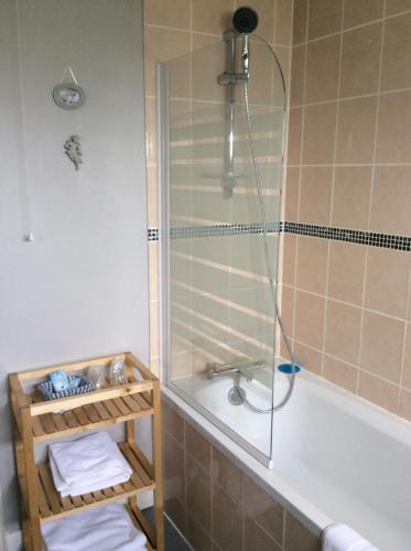 La salle de bains est pourvue d'une douche, d'une baignoire et de serviettes. dans l'établissement La Verte Campagne - 50660 Trelly, à Trelly