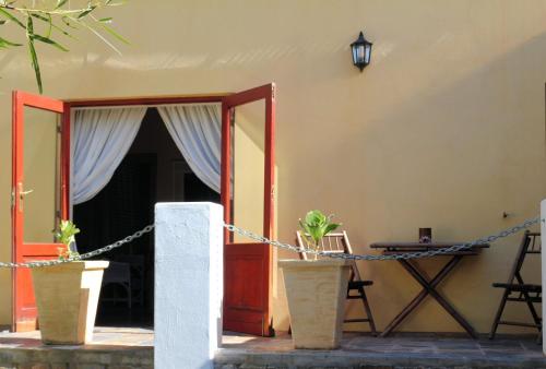 a house with a porch with potted plants at Steytlerville Villa Guest house in Steytlerville