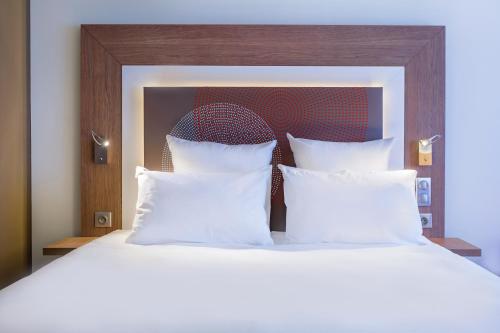 a bedroom with a large bed with white pillows at Novotel Katowice Centrum in Katowice