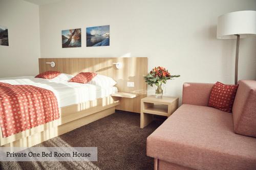 ダボスにあるPrivate Holiday Homes by Solariaのベッドと椅子付きのホテルルーム