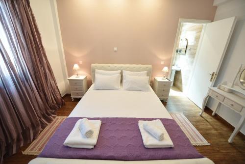 a bedroom with a large bed with two towels on it at Villa Despina Benitses in Benitses