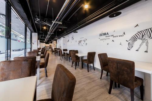 a restaurant with tables and chairs and a wall with a zebra on it at Hotel Fun - Linsen in Taipei