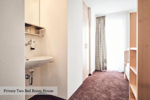 uma casa de banho com um lavatório e um WC num quarto em Private Holiday Homes by Solaria em Davos
