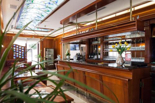 a bar in a restaurant with a vase of flowers at Hotel Villa Venezia in Grado