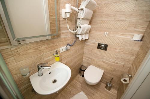 a small bathroom with a sink and a toilet at light hotel & hub in Kyiv