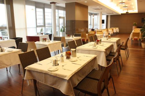 jadalnia ze stołami i krzesłami z białymi obrusami w obiekcie Hotel Famulus w Győr