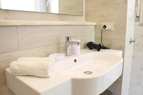 uma casa de banho com um lavatório branco e um espelho. em Taonasi Mazzeo Apartment em Mazzeo