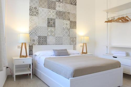 1 dormitorio con 1 cama blanca y 2 lámparas en Taonasi Mazzeo Apartment, en Mazzeo
