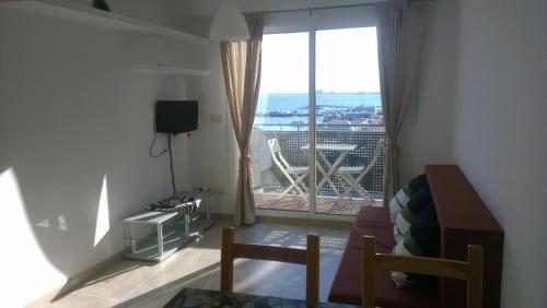 a living room with a large window with a view at Apartaments Josep Pla in Roses