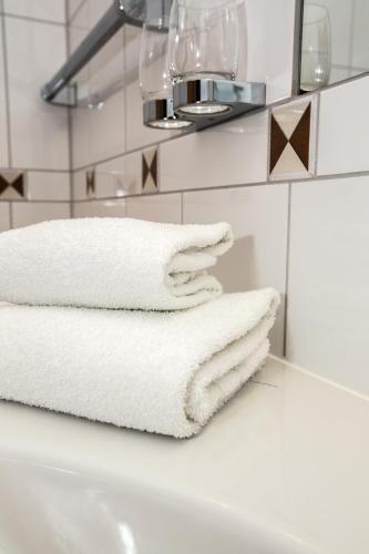 a bathroom with white towels on a sink at Badener Hof in Baden