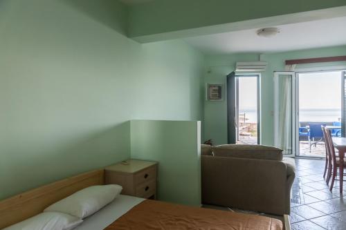 a bedroom with a bed and a couch and a living room at Epidavros Seascape in Ancient Epidavros