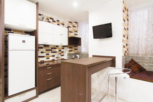 a kitchen with a white refrigerator and a sink at Club Suite near Deribasovskaya in Odesa