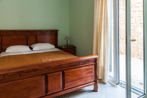 a bedroom with a wooden bed and a window at Epidavros Seascape in Ancient Epidavros