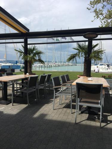 a patio with tables and chairs and a marina at Butique Apartman in Balatonlelle