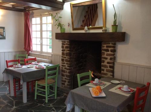 a dining room with two tables and a fireplace at La Verte Campagne - 50660 Trelly in Trelly