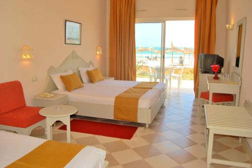 ein Hotelzimmer mit einem Bett und einem Balkon in der Unterkunft Zephir Hôtel & Spa in Zarzis