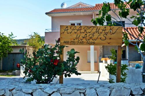 a sign in front of a house with two trees at Apartments Maris in Vinišće
