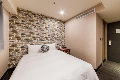 a bedroom with a bed and a brick wall at Hotel Fun - Linsen in Taipei