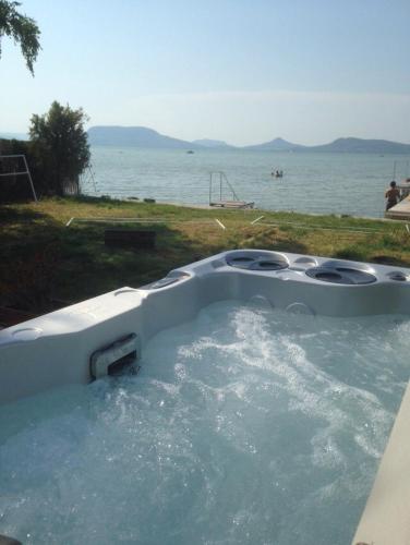 a bath tub filled with water next to a body of water at The Lake House in Fonyód