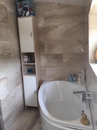 a bathroom with a white tub and a white cabinet at The Lake House in Fonyód