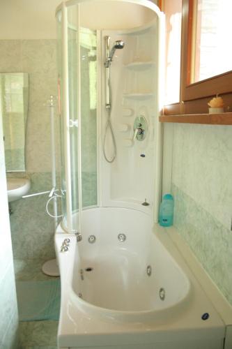 een badkamer met een wit bad en een douche bij B&B La Borma di Pombo in Pontboset