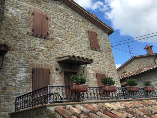 a building with a balcony with potted plants on it at Appartamenti e Camere Il Poggio di D'Angeli Lidia in Auditore
