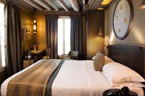 a bedroom with a large bed and a desk at Hôtel Les Dames du Panthéon in Paris