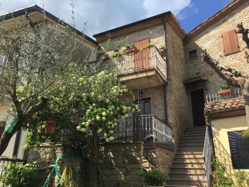 a building with stairs and a tree in front of it at Appartamenti e Camere Il Poggio di D'Angeli Lidia in Auditore