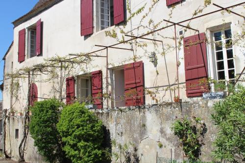 an old house with red shuttered windows at L'Ancien Couvent Cahuzac in Cahuzac