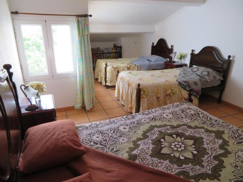 una camera con tre letti e una finestra e una camera con due letti di Casa Formosa a Furnas