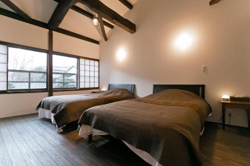 two beds in a room with two windows at Hashiba-an in Kanazawa