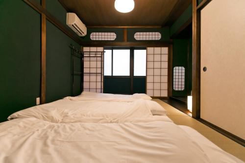 a bedroom with two white beds in a room at Hashiba-an in Kanazawa