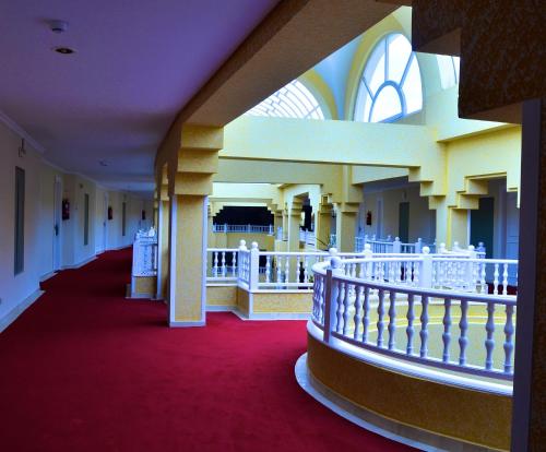a hallway with a red carpet and a balcony at Royal Garden Palace - Families and Couples in Midoun
