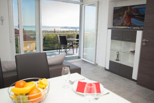 a living room with a table with a bowl of fruit on it at Lakeview Apartments Balatonfüred in Balatonfüred