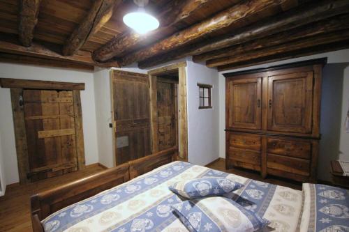 アオスタにあるVecchio Fienileの木製の天井と木製キャビネットが備わるベッドルーム1室を提供しています。