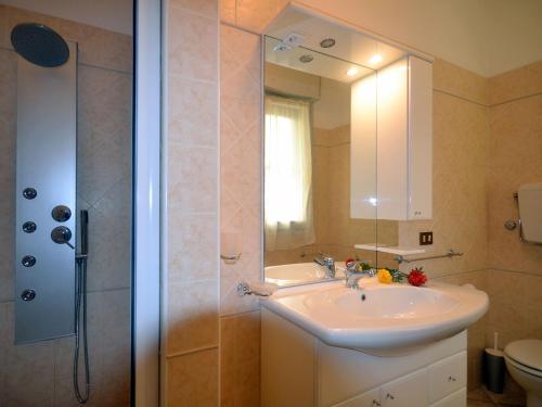 a bathroom with a sink and a shower with a mirror at SIT Holiday Homes in Lido delle Nazioni