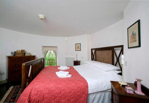 a bedroom with a large bed with a red blanket at Drum Gatelodge in Bushmills