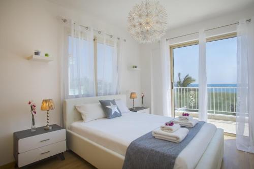 a bedroom with a large bed and a large window at Villa Iris in Mazotos