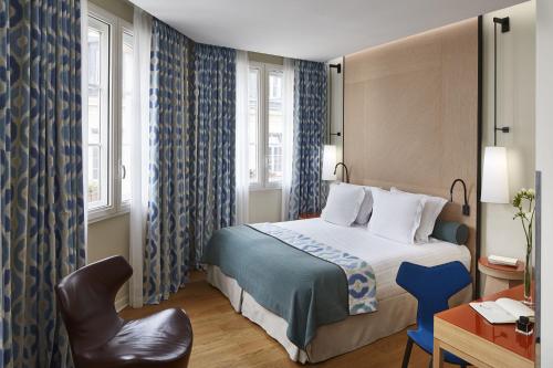 une chambre d'hôtel avec un lit et une chaise dans l'établissement Hôtel Bel Ami, à Paris