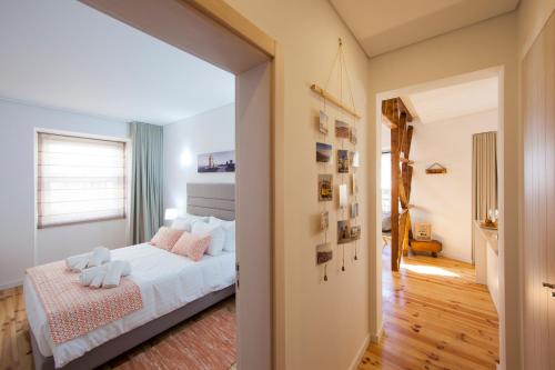 リスボンにあるFishermenApartments - Santos 3Dのベッドルーム1室(白いシーツとピンクの枕が備わるベッド1台付)