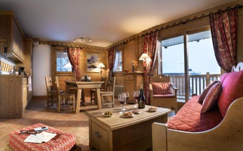 a living room with a couch and a table at CGH Résidences & Spas Les Granges Du Soleil in La Plagne